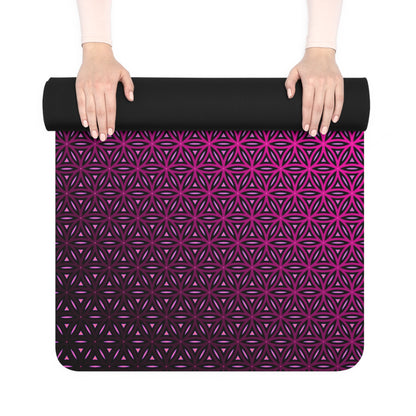 Yoga mat being unrolled by hand, showing the black rubber underside of the Pink Flower of Life design