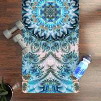 Return to Purity yoga mat laid flat on a wood floor beside dumbbells and a water bottle, mandala print up close.