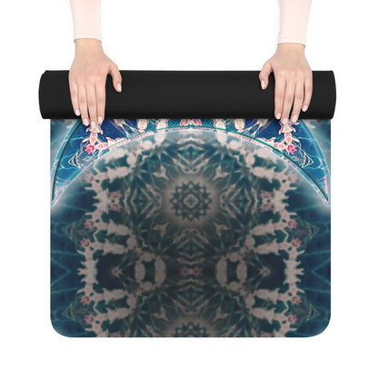 Two hands rolling up a Triple Goddess yoga mat, revealing its black rubber underside and colorful mandala edge.