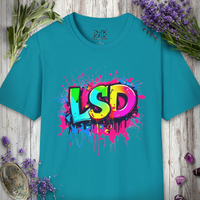 Teal t-shirt with the rainbow LSD Splatter graffiti design, laid flat on wood with sage and lavender.