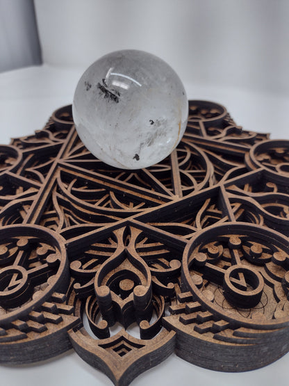 Angled view of the Harvest Abundance wall art crystal grid showing the laser-cut flower of life detail.