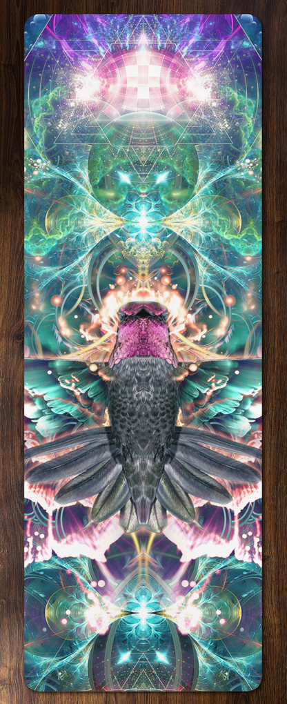 Nectar yoga mat laid flat on a wood floor showing a mirrored hummingbird surrounded by cosmic sacred geometry art.