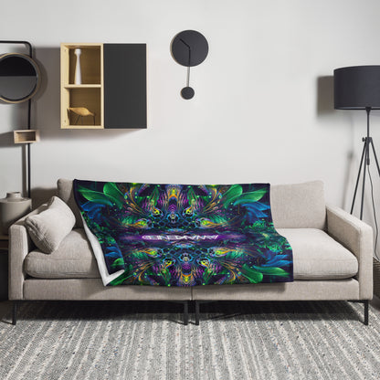 The "Awakened" throw blanket draped over a couch, corner folded to show the white reverse side