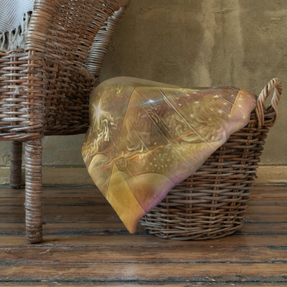 The "Celestial Vibrations" throw blanket draped over a couch, corner folded to show the white reverse side