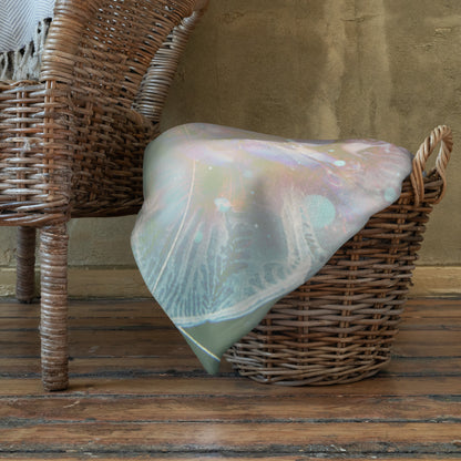 "Primordial Soup" throw blanket draped over the arm of a chair, showing the full print.