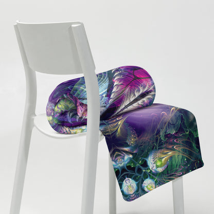 The "Emergence" throw blanket draped over a couch, corner folded to show the white reverse side