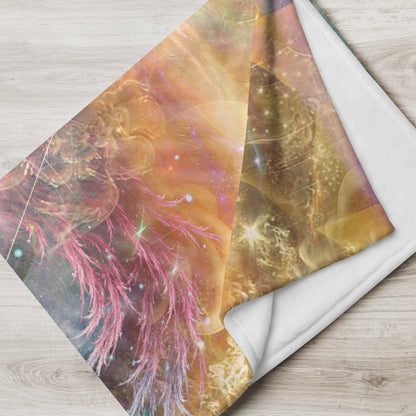 The "Celestial Vibrations" throw blanket draped over a couch, corner folded to show the white reverse side